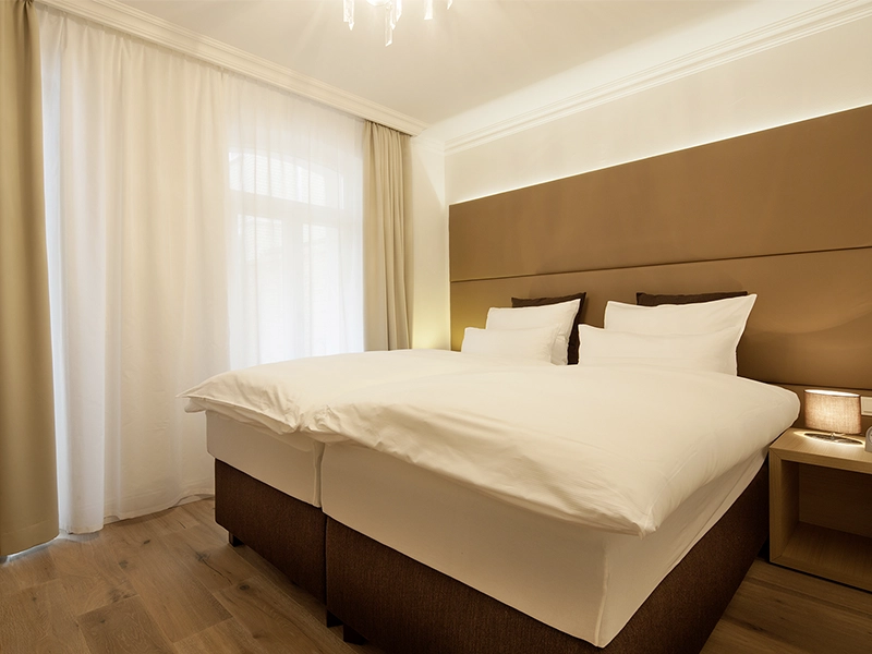 Blick in das Apartment Maison et Spa N° 2 der Villa Vie auf Norderney. Zu sehen ist das Hauptschlafzimmer mit großen Doppelbett.