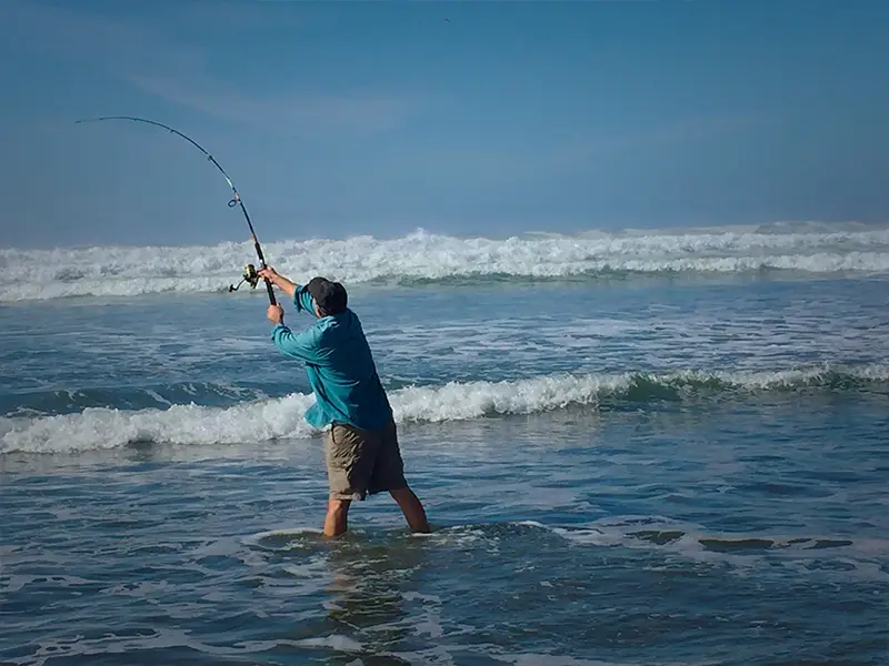 Zu sehen ist ein Angler, der bei der Brandung der Norderney seine Beute auswirft.