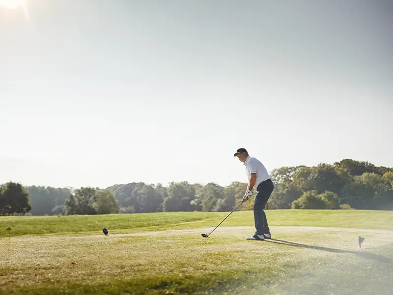 Zu sehen ist ein ambitionierter Golfer, der seinen Urlaub auf der Norderney genießt und einen Ball schlägt.
