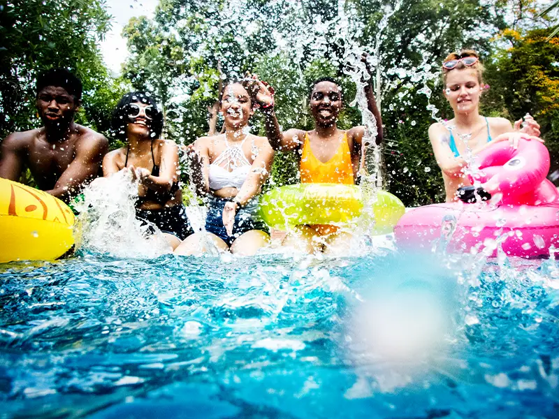 Zu sehen sind Kinder, die mit Wasser spritzen und Spaß haben im Spaßbad auf Norderney.