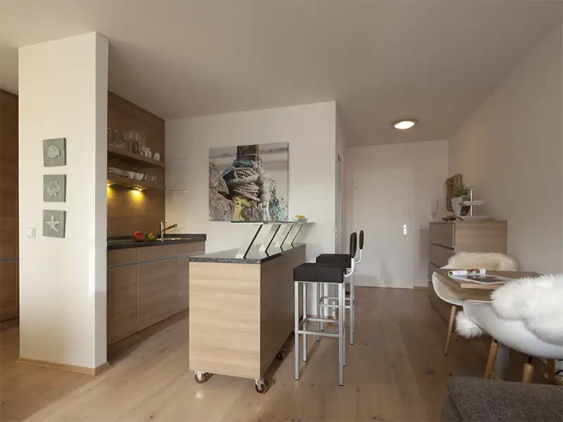 Das Apartment Nordseeblick der Villa Vie auf Norderney. Auf dem Bild sieht man den Küchenbereich mit Barhockern.