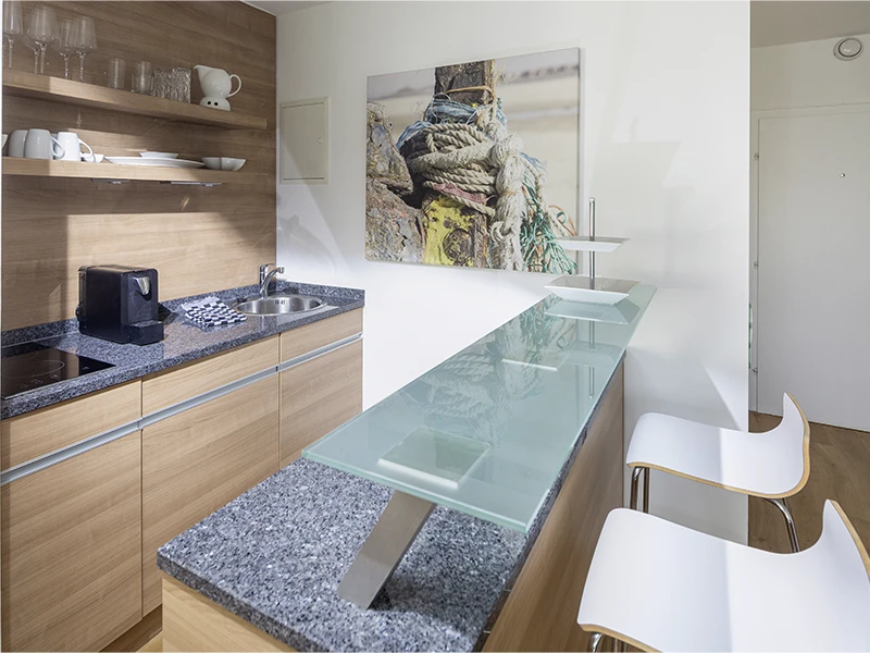 Moderne Küchenzeile im Apartment Nordseeblick mit Tresen, Barhockern und Holzfronten