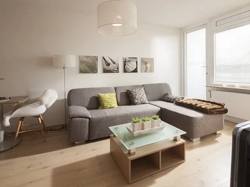 Das Apartment Nordseeblick der Villa Vie auf Norderney. Auf dem Bild sieht man den Wohnbereich mit Couch und Couchtisch.